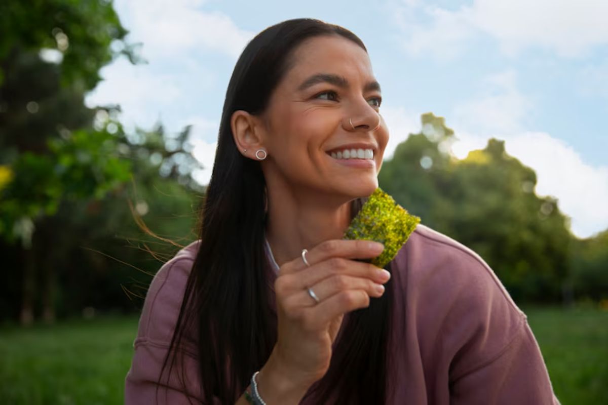 Uma mulher comendo o Vegetal que aumenta a felicidade 