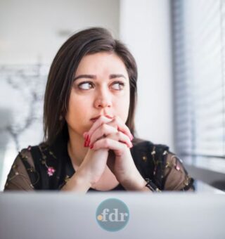 Uma mulher preocupada em frente ao computador ao ver o ChatGPT fora do ar