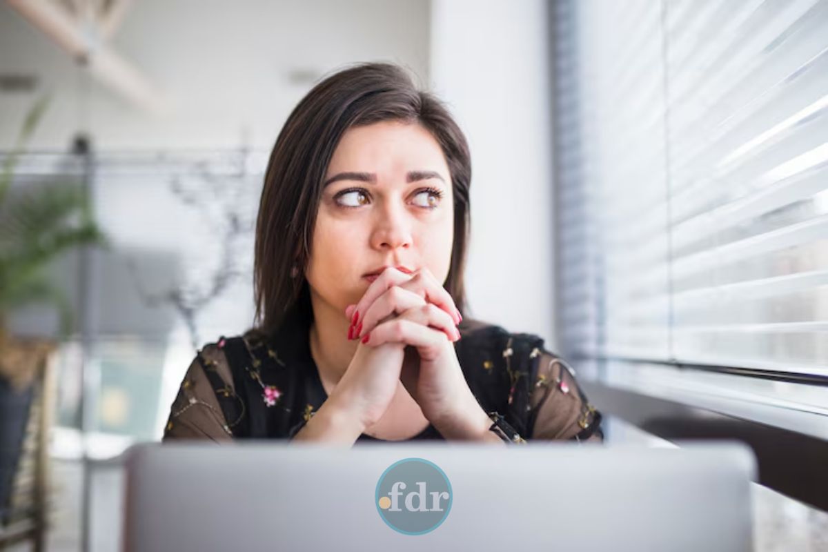 Uma mulher preocupada em frente ao computador ao ver o ChatGPT fora do ar