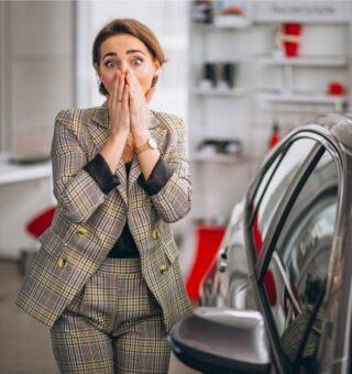Uma mulher assustada ao ver os novos preços dos carros em 2025