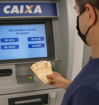Um homem sacando seu benefício exclusivo no caixa eletrônico