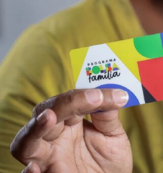 Uma pessoa segurando o cartão da Bolsa Família