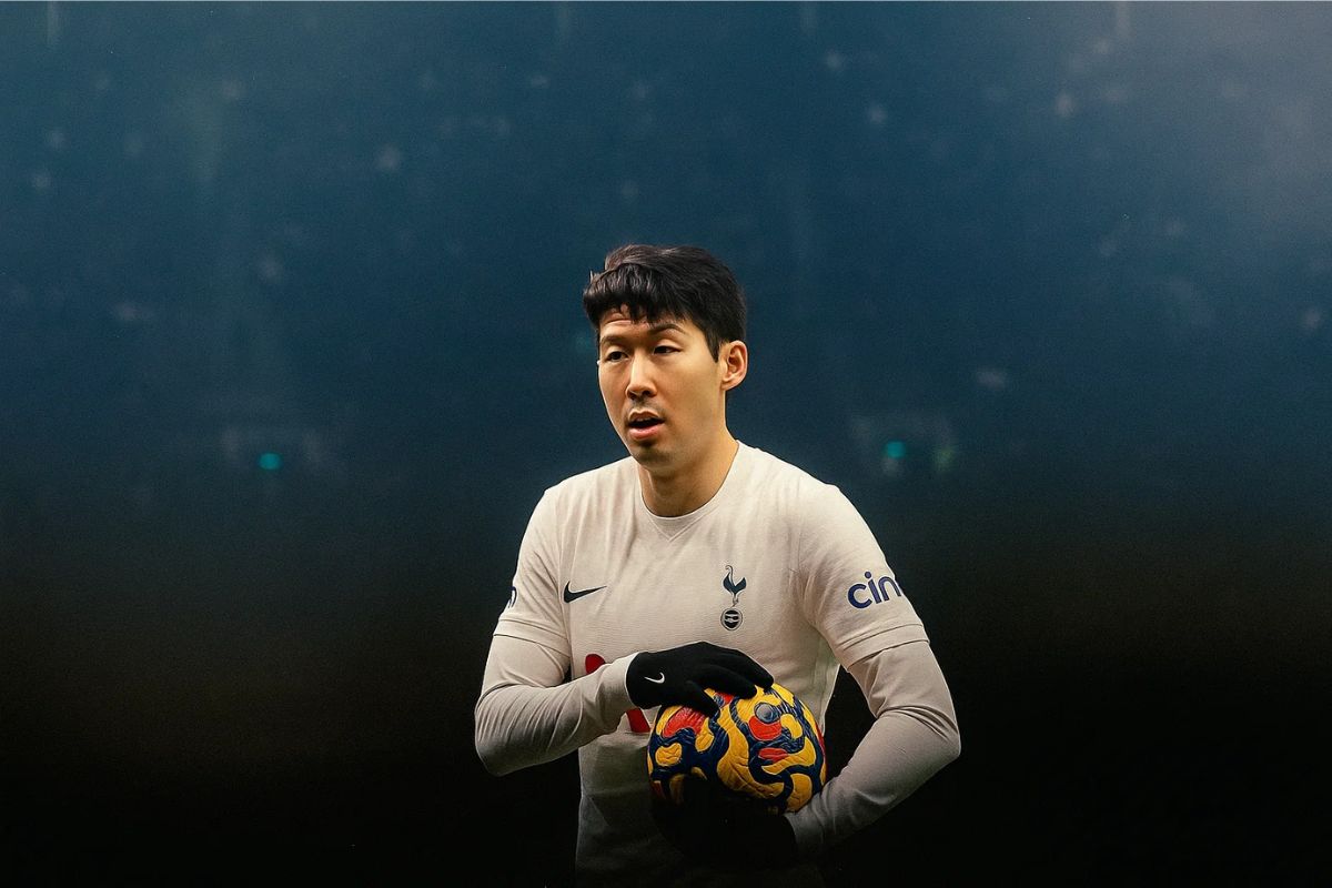 Son segurando uma bola de futebol