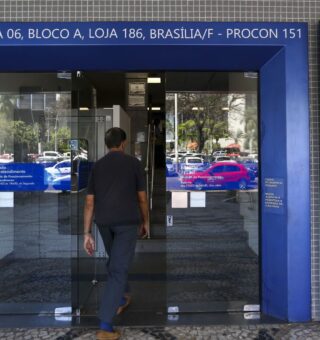 Uma pessoa em frente à agência da Caixa Econômica Federal