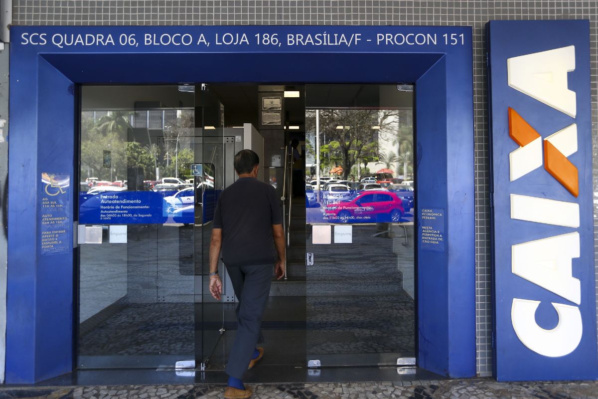 Uma pessoa em frente à agência da Caixa Econômica Federal