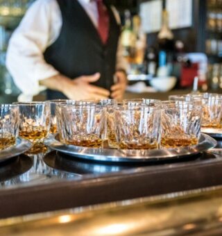Um garçom servindo whisky sem pesar em Intoxicação por metanol