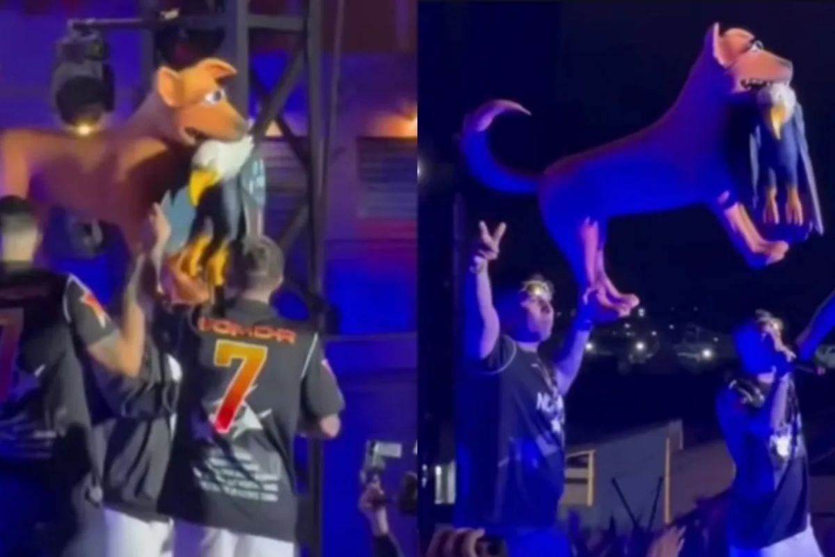 MC Hariel em cima do palco com o cachorro caramelo mordendo a águia (símbolo norte-americano)