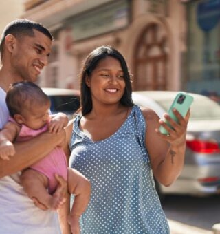Uma família, pai, filha no colo e mãe, se animam com o feriado prolongado de Outubro