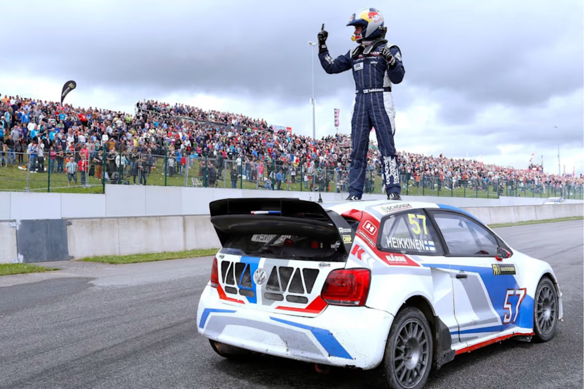 Um corredor de Rallycross em cima do seu carro comemora a vitória