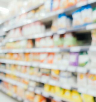 Prateleira embaçada onde ficam produtos como refrigerante