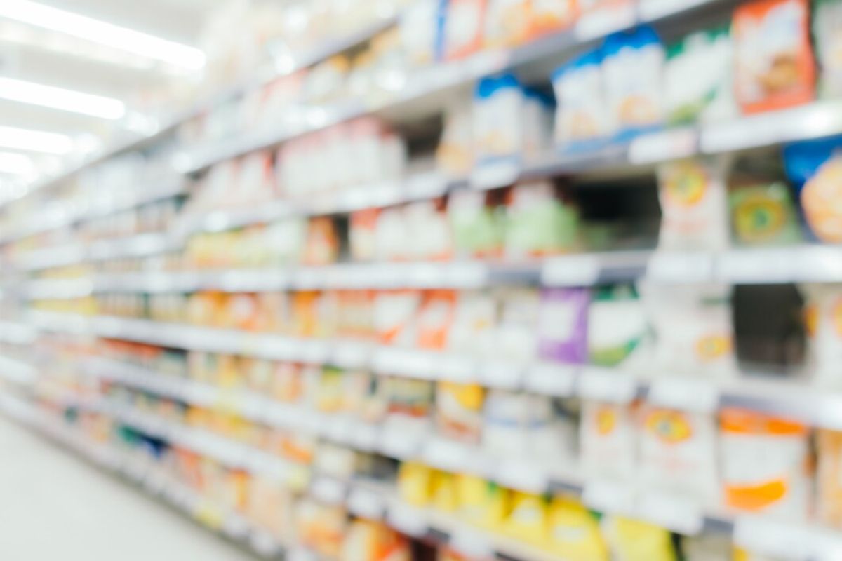 Prateleira embaçada onde ficam produtos como refrigerante