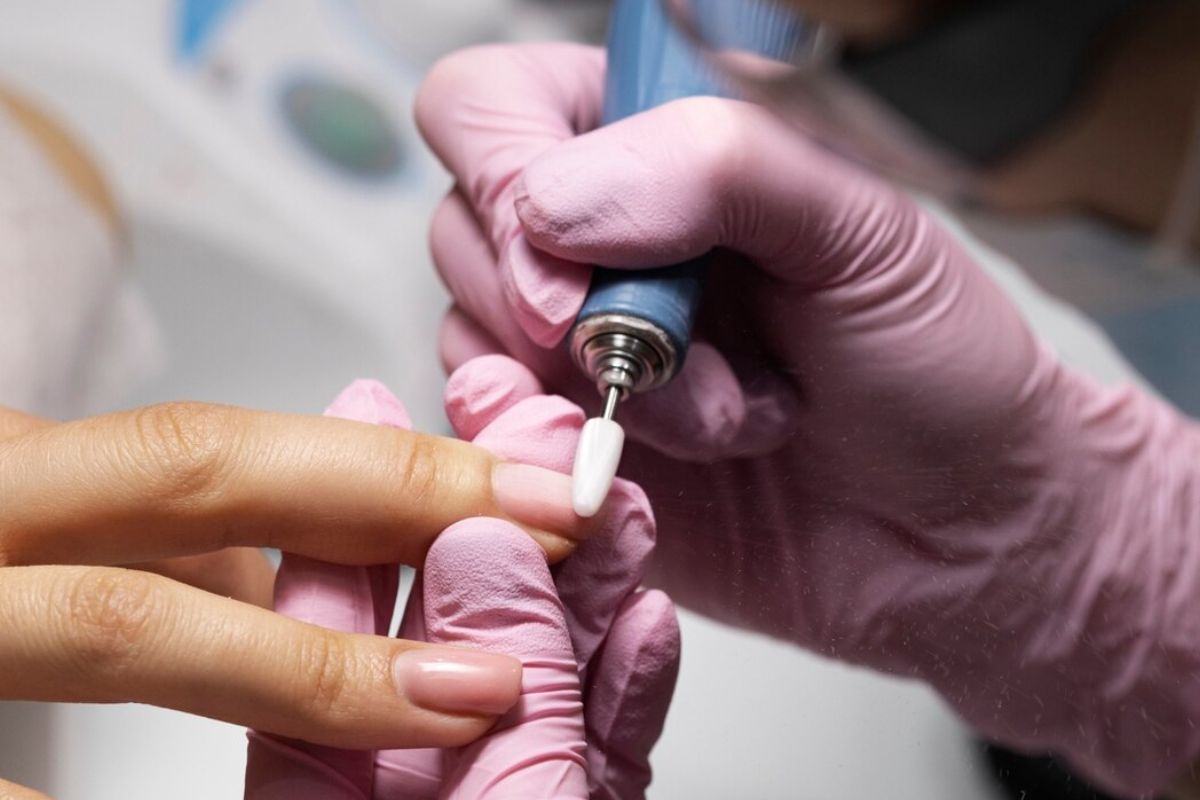 Uma mulher no procedimento de Unha de acrílico no salão