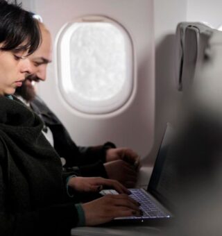 Pessoas em um Voo usando o notebook