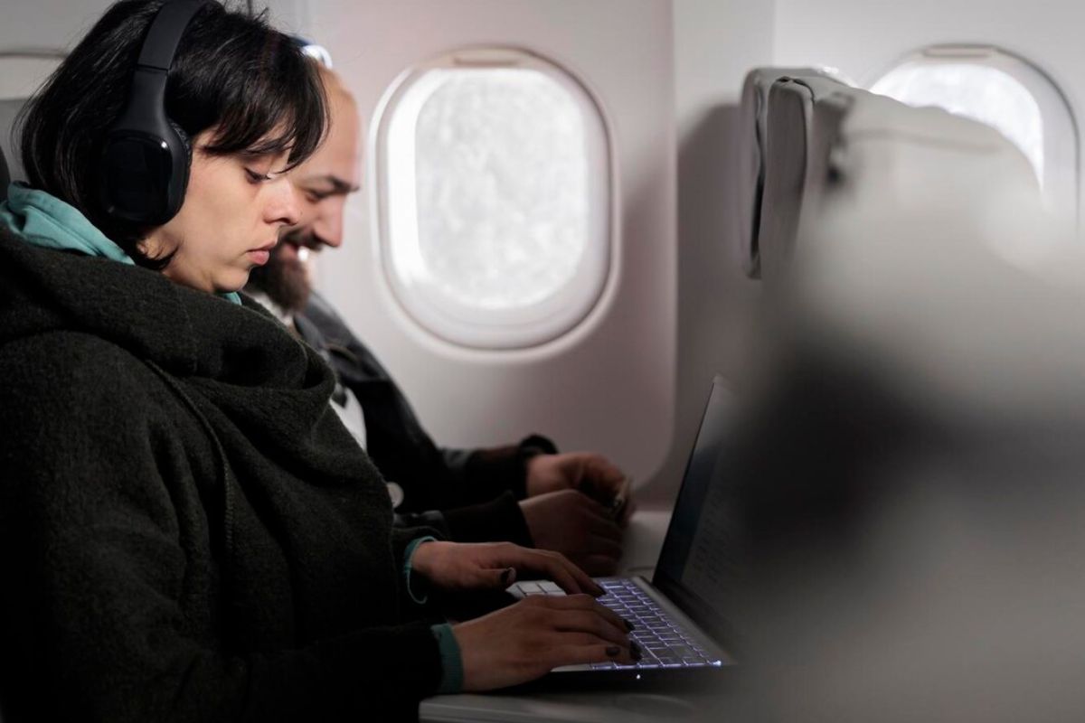 Pessoas em um Voo usando o notebook