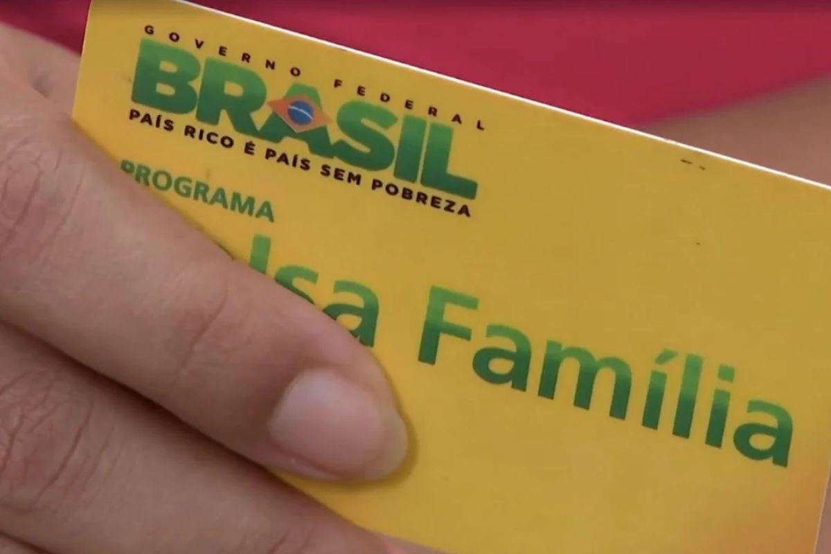 Uma pessoa segura o cartão do Bolsa Família