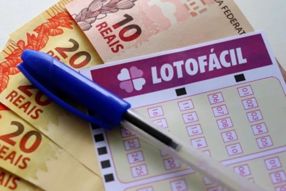 Bilhete da Lotofácil em cima de algumas notas