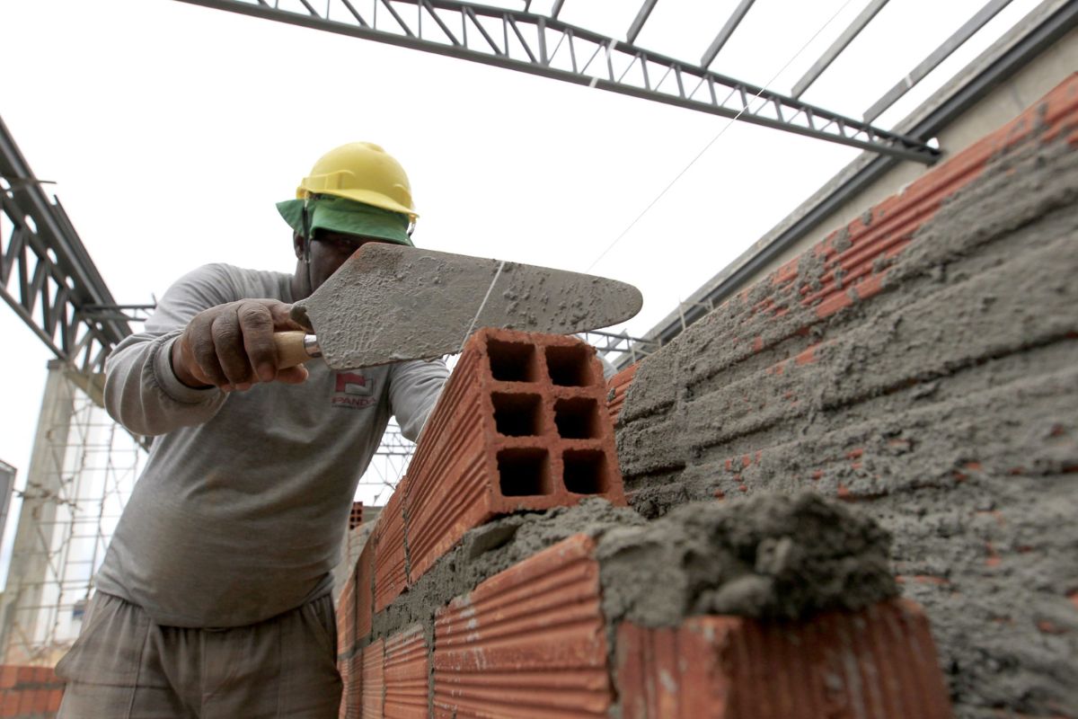 Um pedreiro construindo um muro