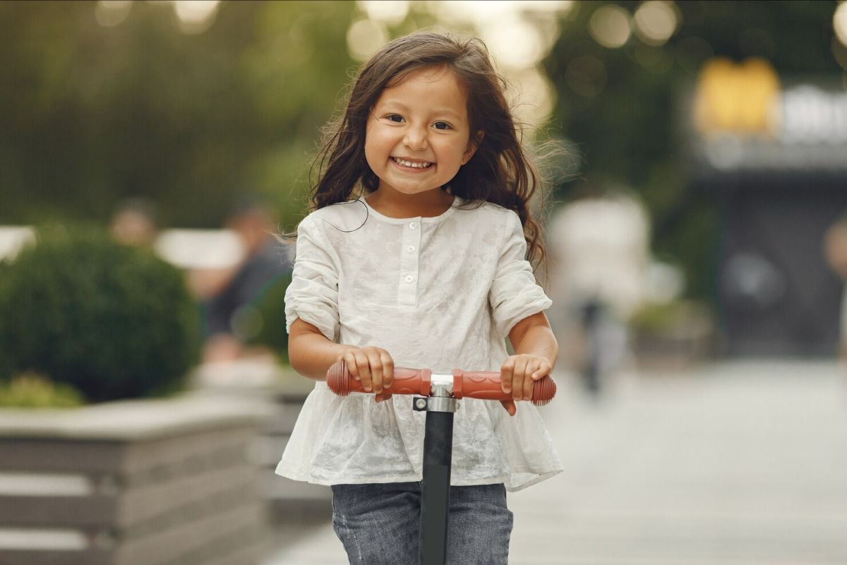 Uma criança andando de patinete feliz
