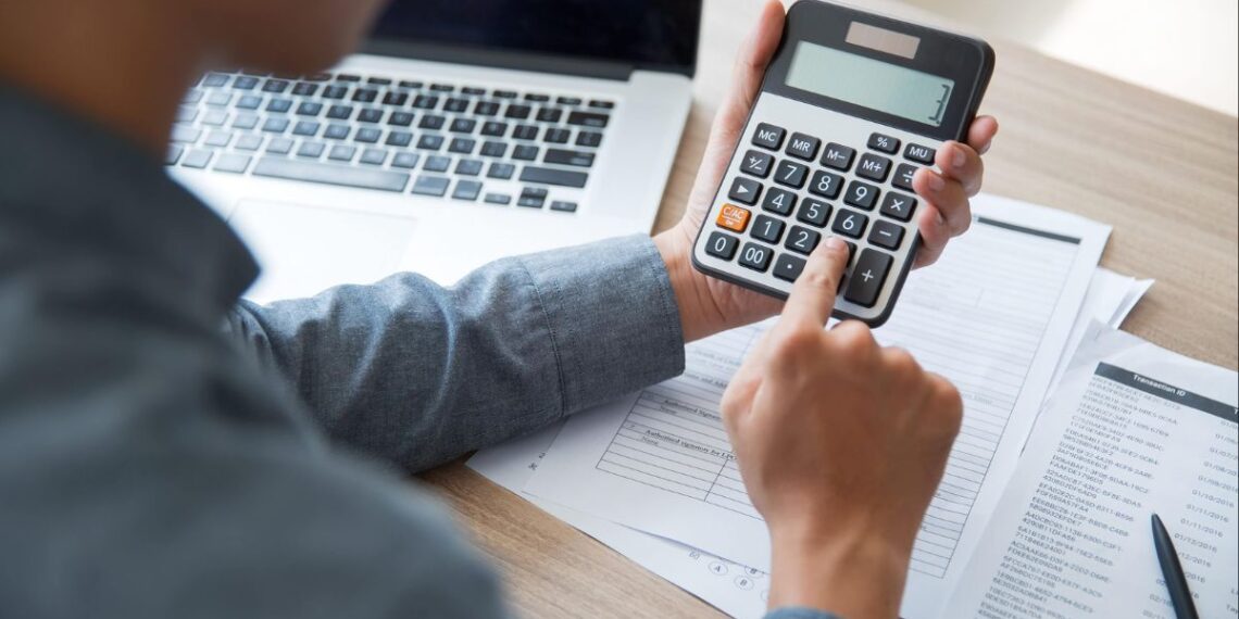Uma pessoa com calculadora organiza suas dívidas
