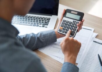 Uma pessoa com calculadora organiza suas dívidas