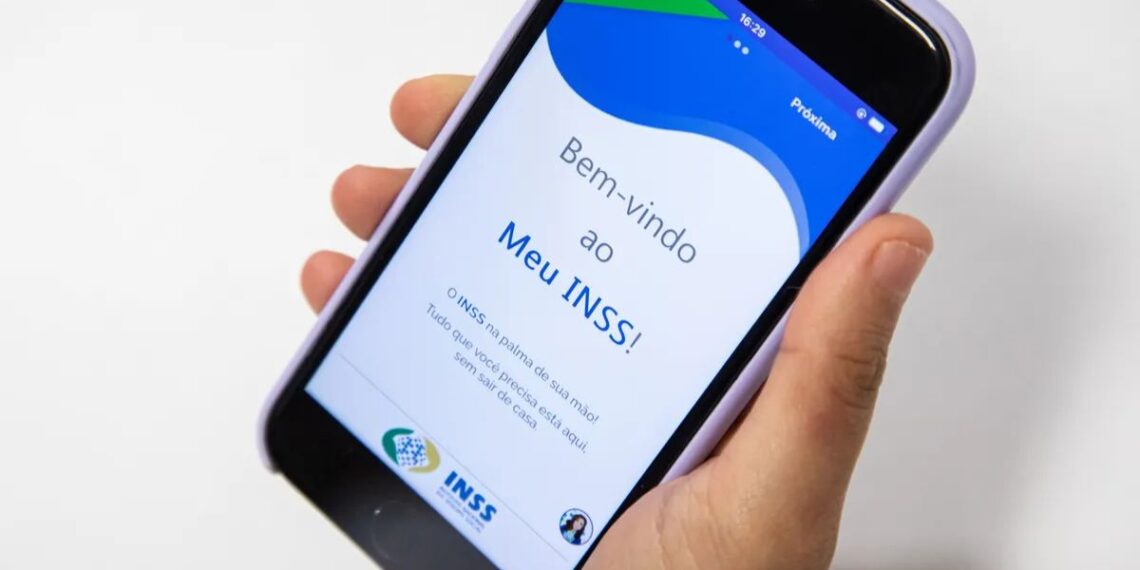 Aplicativo Meu INSS no celular na mão de uma pessoa