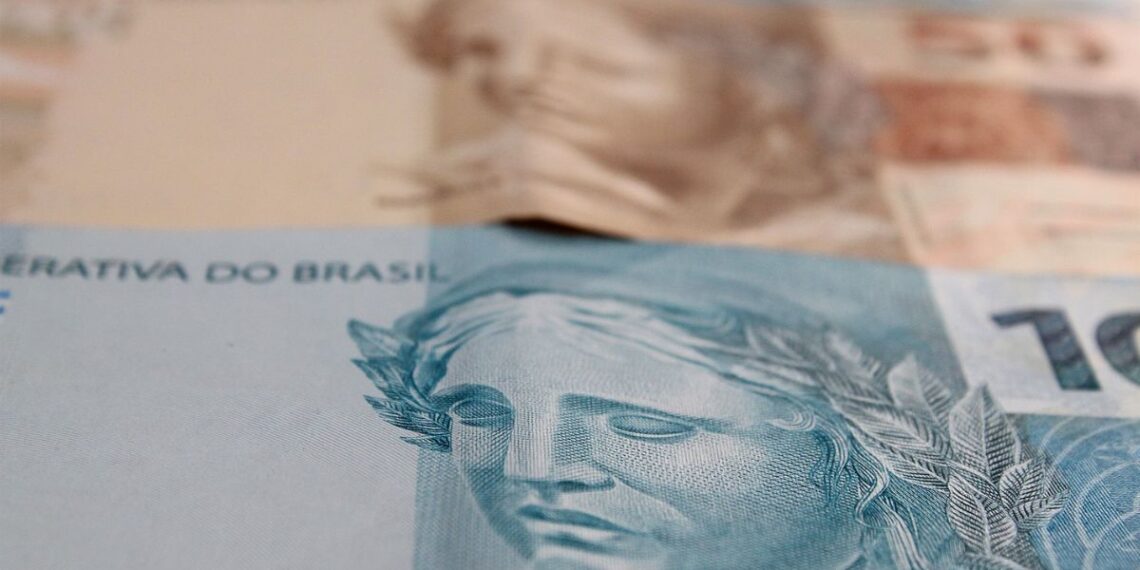 Imagem de notas de R$ 100  e R$ 50 do salário no 5º dia útil