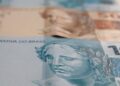 Imagem de notas de R$ 100  e R$ 50 do salário no 5º dia útil