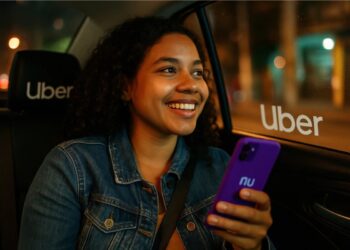 Uma mulher dentro do Uber com celular na mão