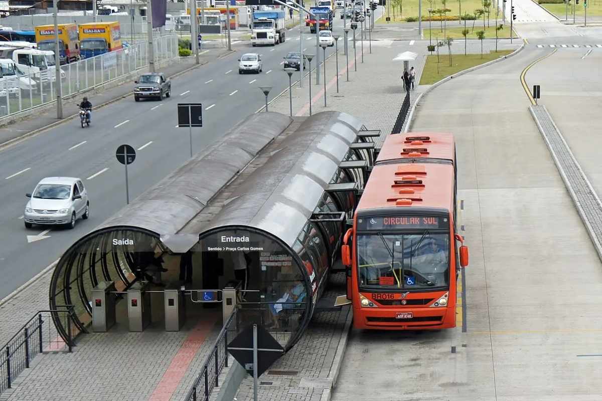 Transporte público - um ônibus vermelho no ponto